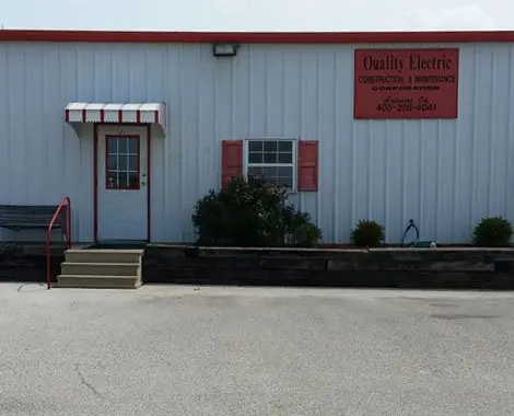 The Quality Electric building in Ardmore, a white metal shop with a red door and the company name painted on the wall.
